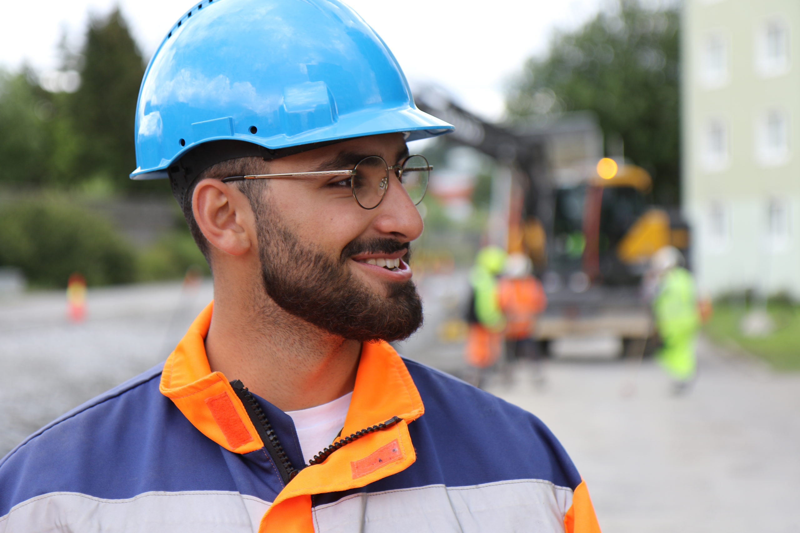 En smilende Mesta-ansatt i blå hjelm