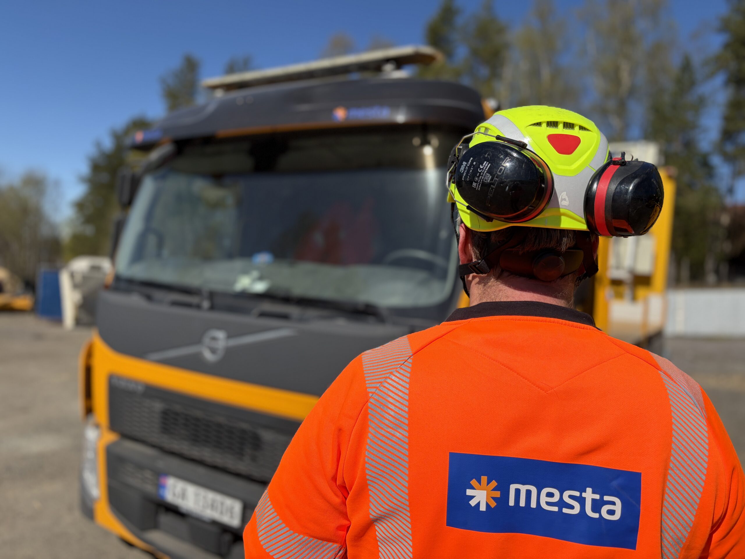 Mesta mann med ryggen til. Lastebil